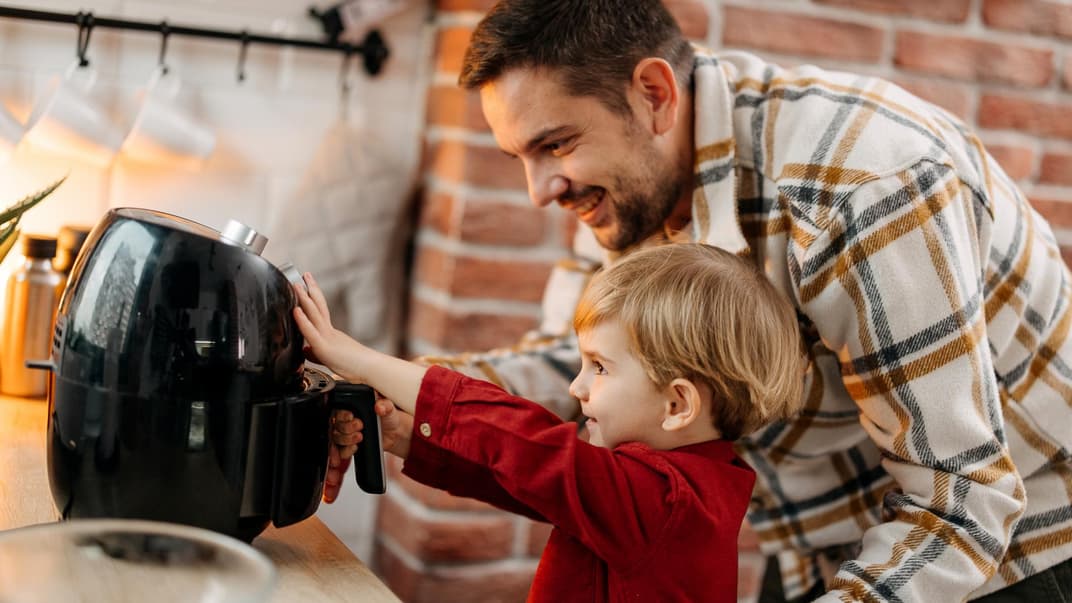 Ein Vater mit Sohn an der Heißluftfritteuse