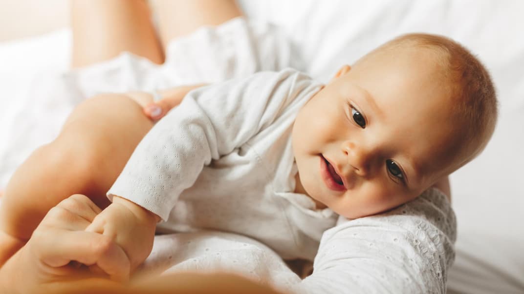 Baby liegt im Arm der Mutter.