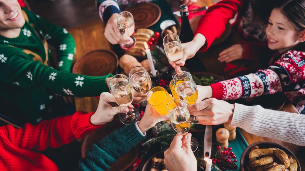 Zu Weihnachten stößt eine Familie mit Gläsern an. 