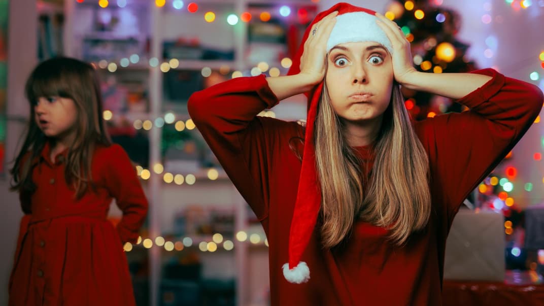 Mutter schlägt an Weihnachten die Hände über dem Kopf zusammen.