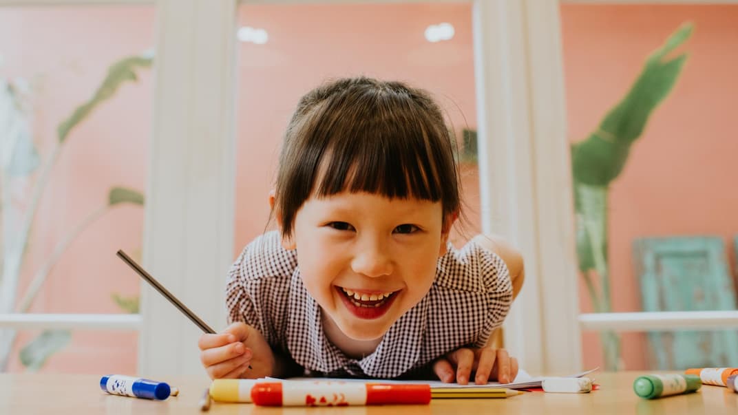 Mädchen lacht in die Kamera.