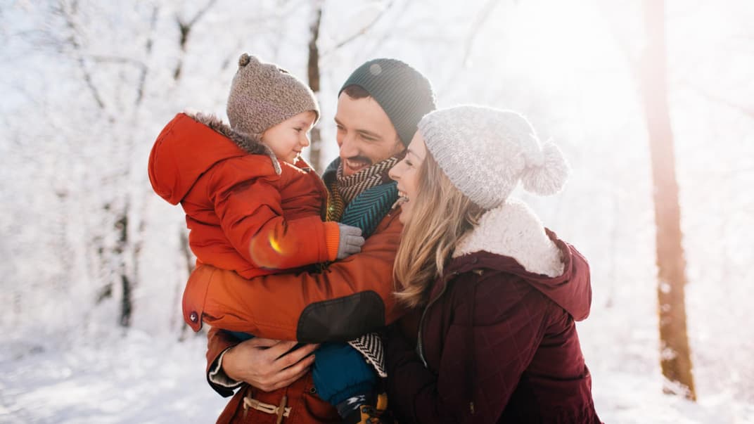 Lachende Familie im Schnee.
