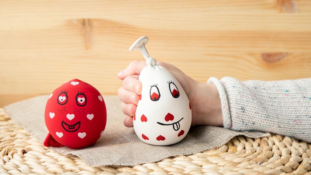 Kinderhand und zwei selbst gemachte Stressbälle.