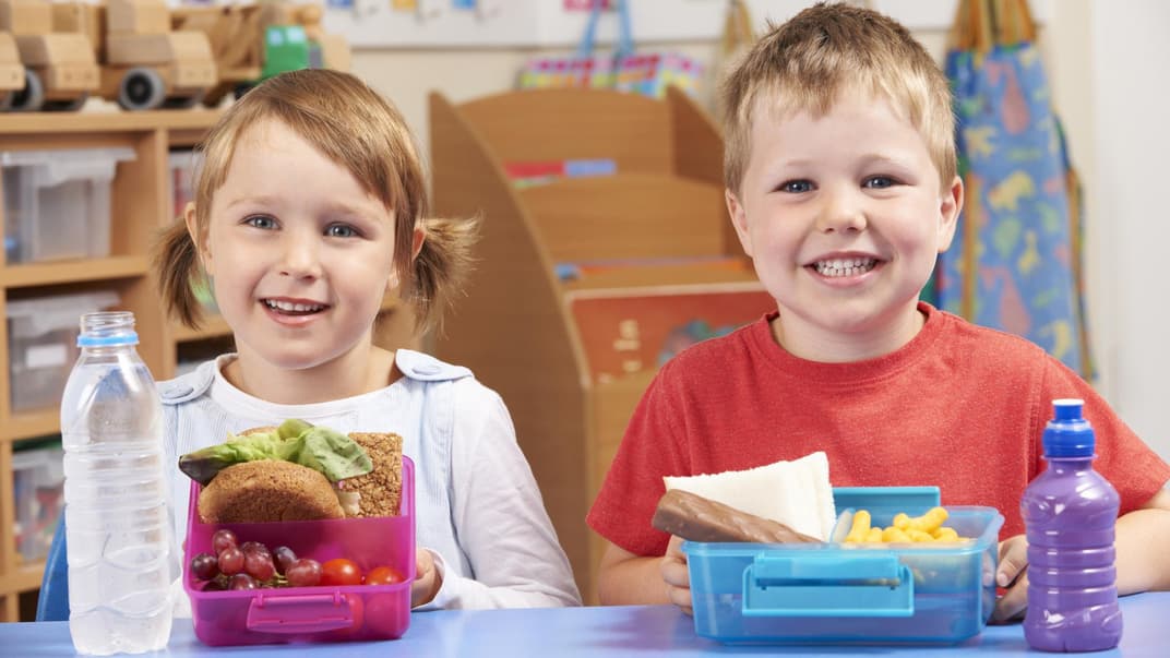 Zwei Kinder mit unterschiedlichen Brotdosen.