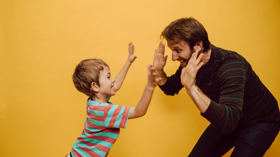 Ein Papa und Sohn klatschen ab.