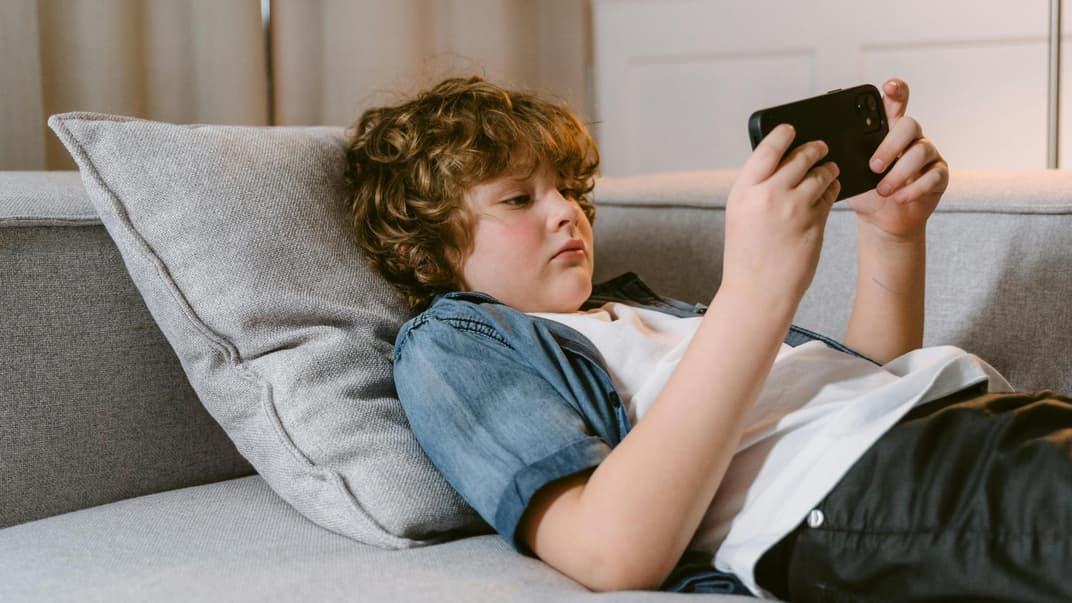 Junge spielt auf dem Smartphone.