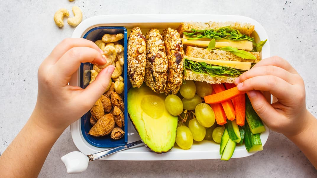 Brotdose mit Kinderhänden.