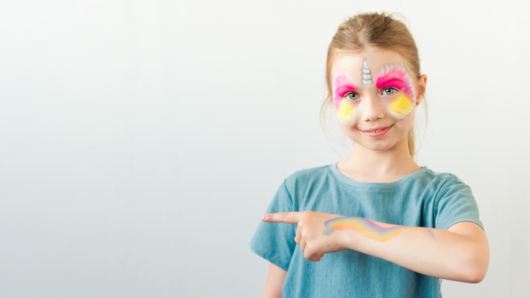 Kleines Mädchen als Einhorn geschminkt.