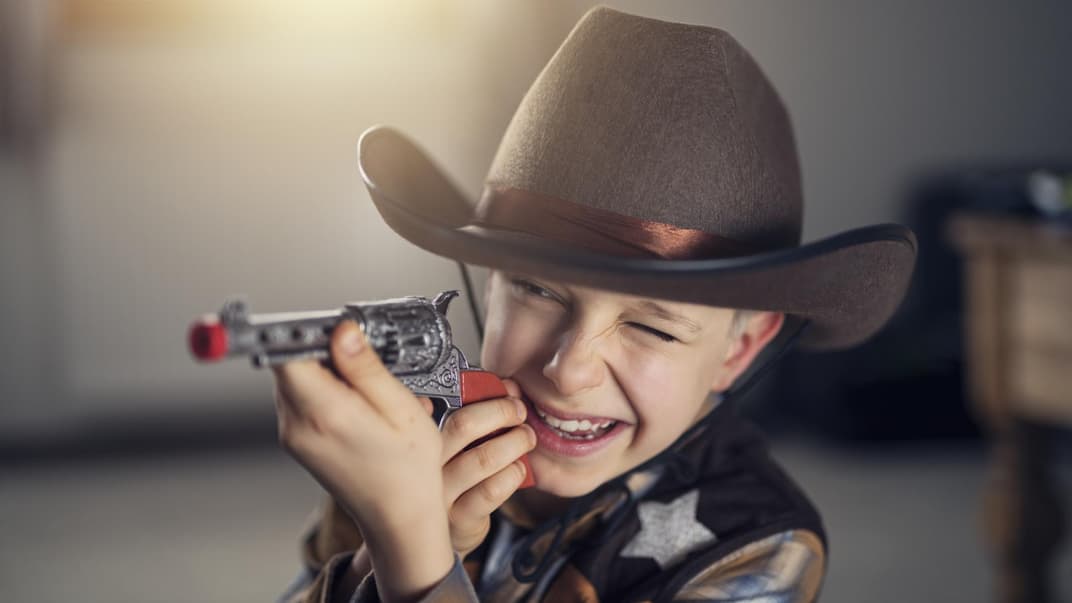 Ein Junge als Cowboy mit Spielzeugpistole