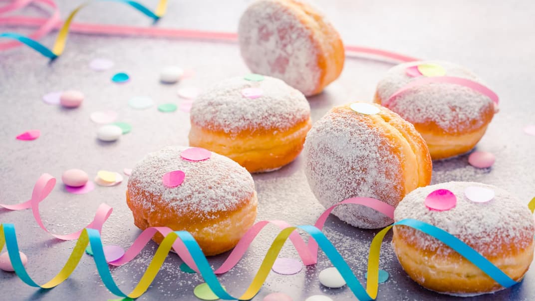 Berliner mit Puderzucker, Luftschlangen und Konfetti.
