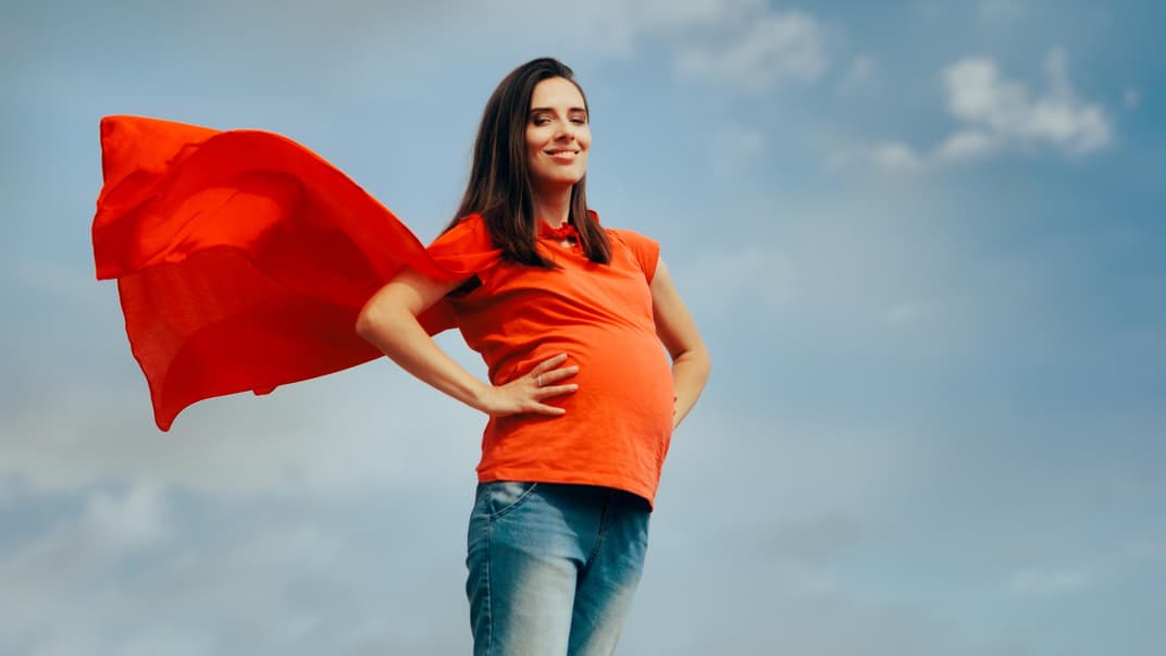 Schwangere Frau als Superheldin.