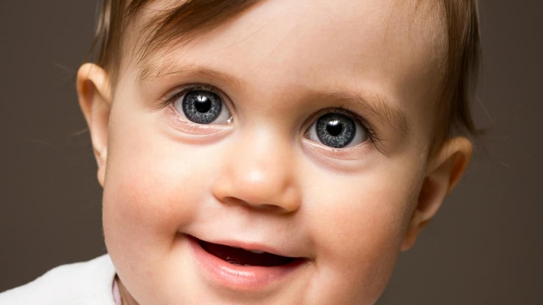 Ein süßer Baby-Junge lächelt in die Kamera. 