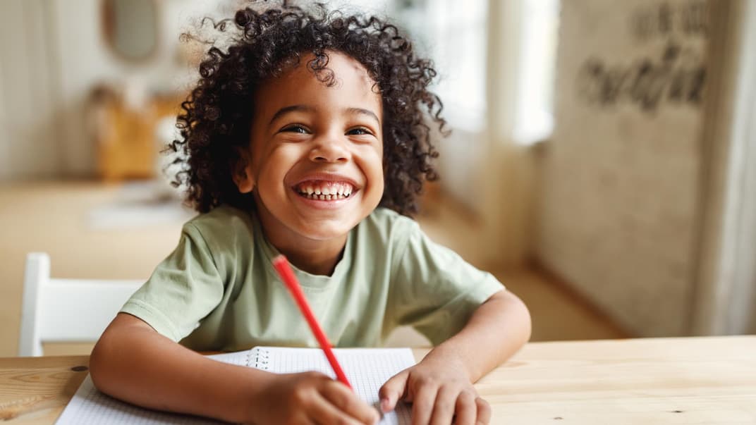 Lachender Junge vor seinem Block.