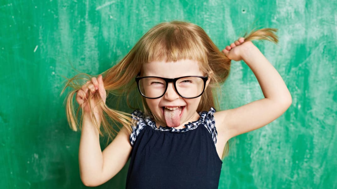 Lachendes Mädchen vor der Tafel.