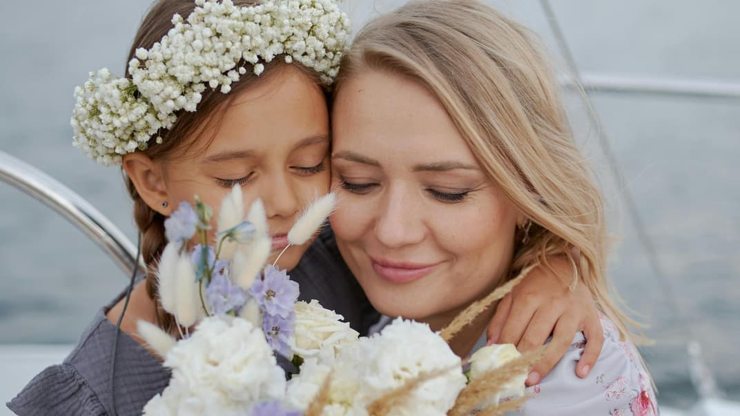 Ein Mädchen schenkt seiner Mutter Blumen zum Muttertag. 