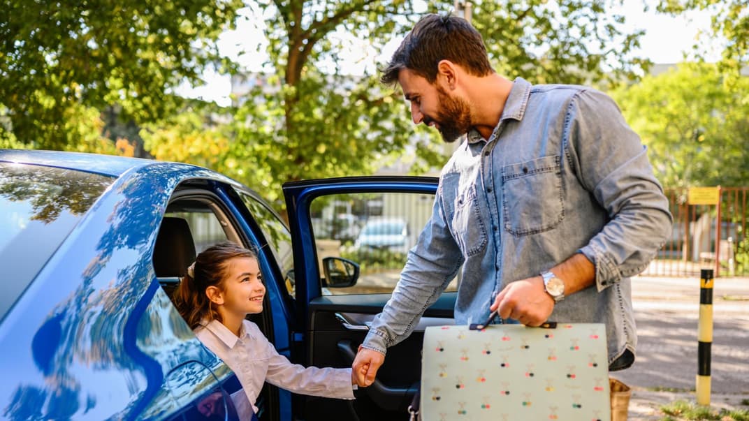 Ein Vater bringt seine Tochter zur Schule
