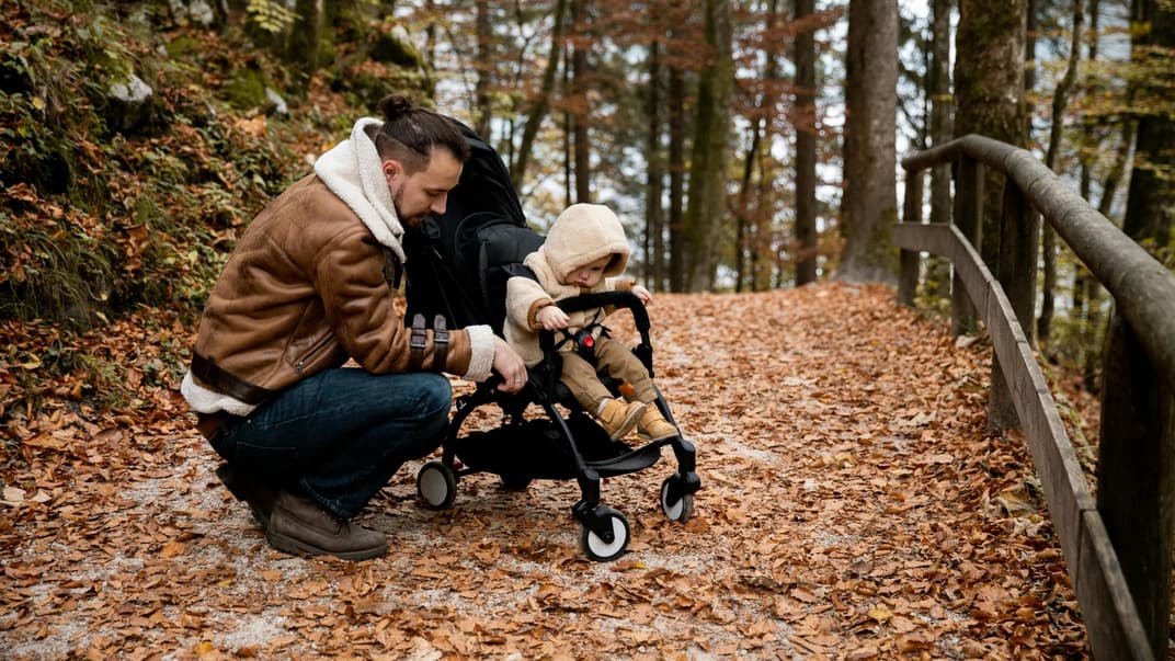 Vater mit Kind im Herbstwald.