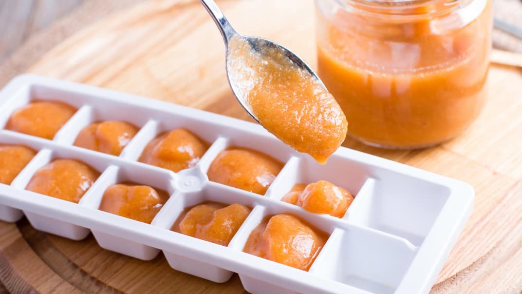 Babybrei in Eiswürfelbehälter füllen.