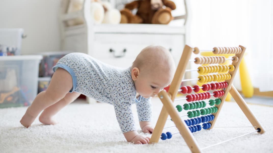 Ein kleines Baby spielt mit einem Rechenschieber.