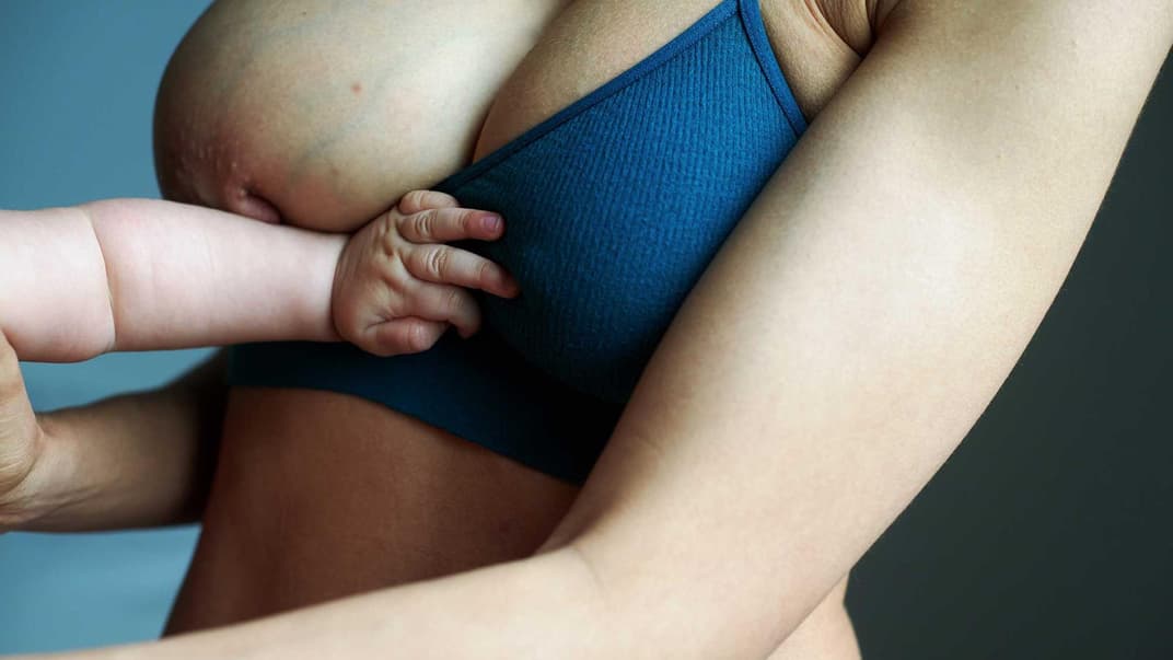 Babyarm an Mutterbrust