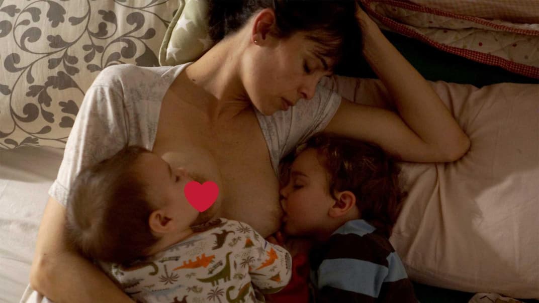 Mutter stillt zwei unterschiedlich alte Kinder gleichzeitig.