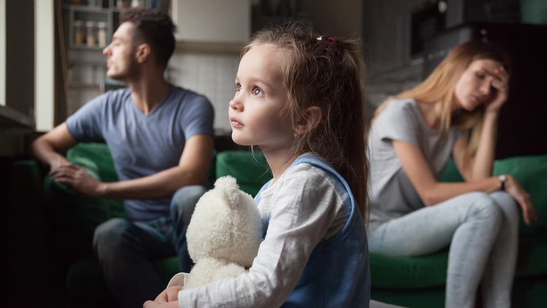 Ein junges Elternpaar streitet sich vor seinem Kind.