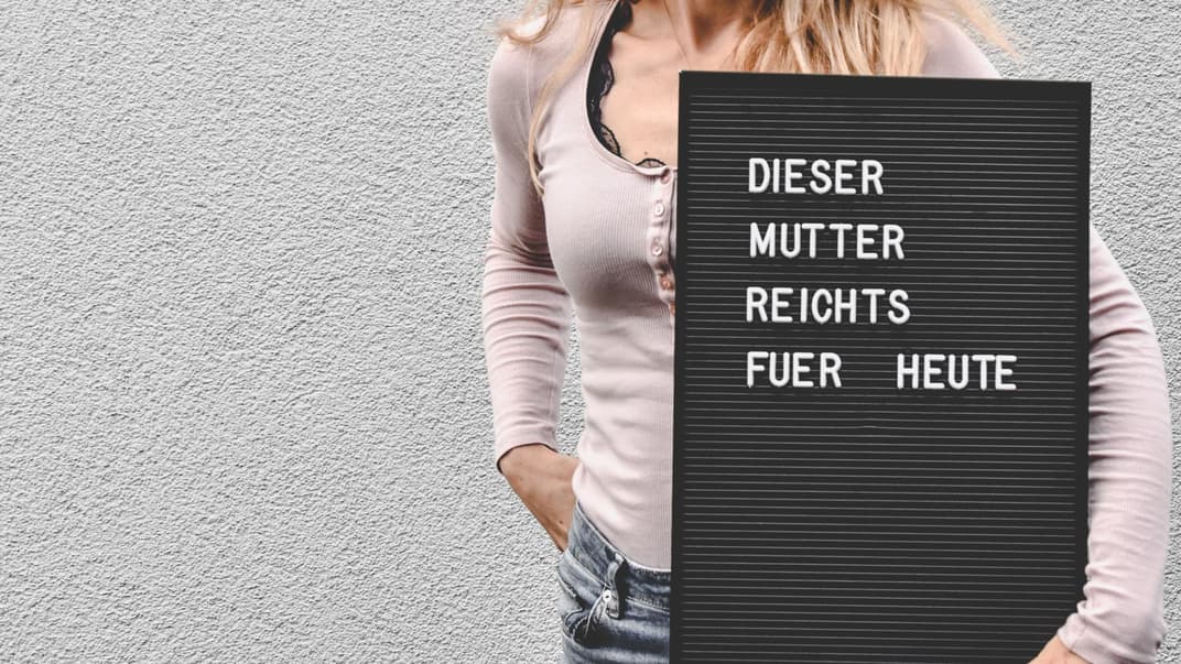 Frau mit Schild "Dieser Mutter reicht's für heute".