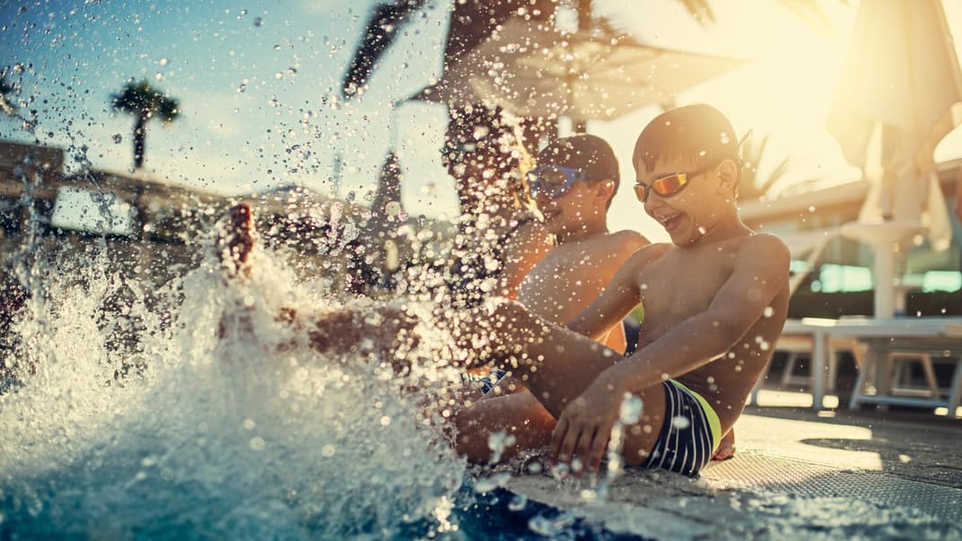 Kinder planschen am Pool.