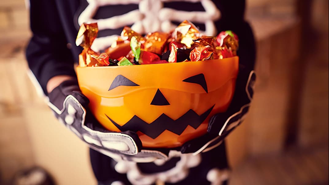 Kind hält Halloween-Schale.