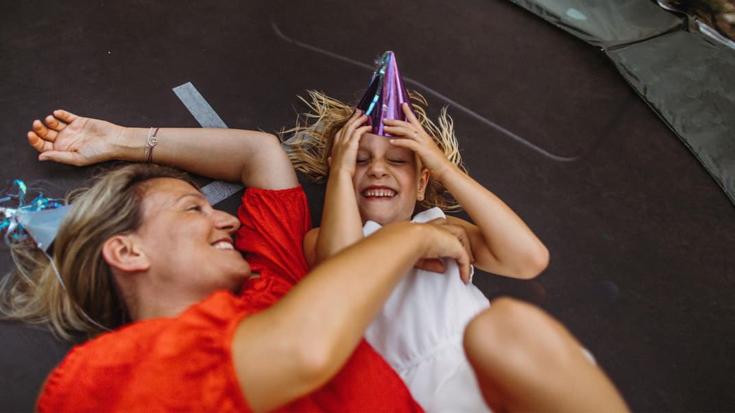 Mutter und Kind liegen auf Trampolin.