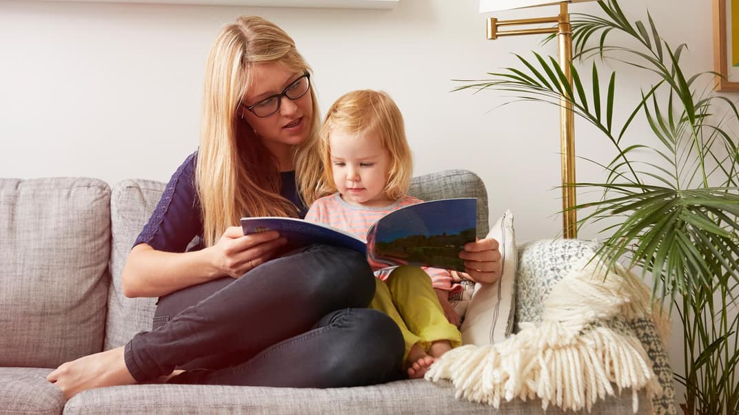 Mutter liest mit Kind ein Buch.