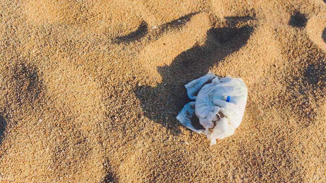 Eine dreckige Windel liegt am Strand