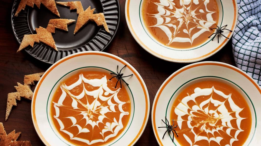 Halloween-Kürbissuppe mit Spinnennetzmuster.