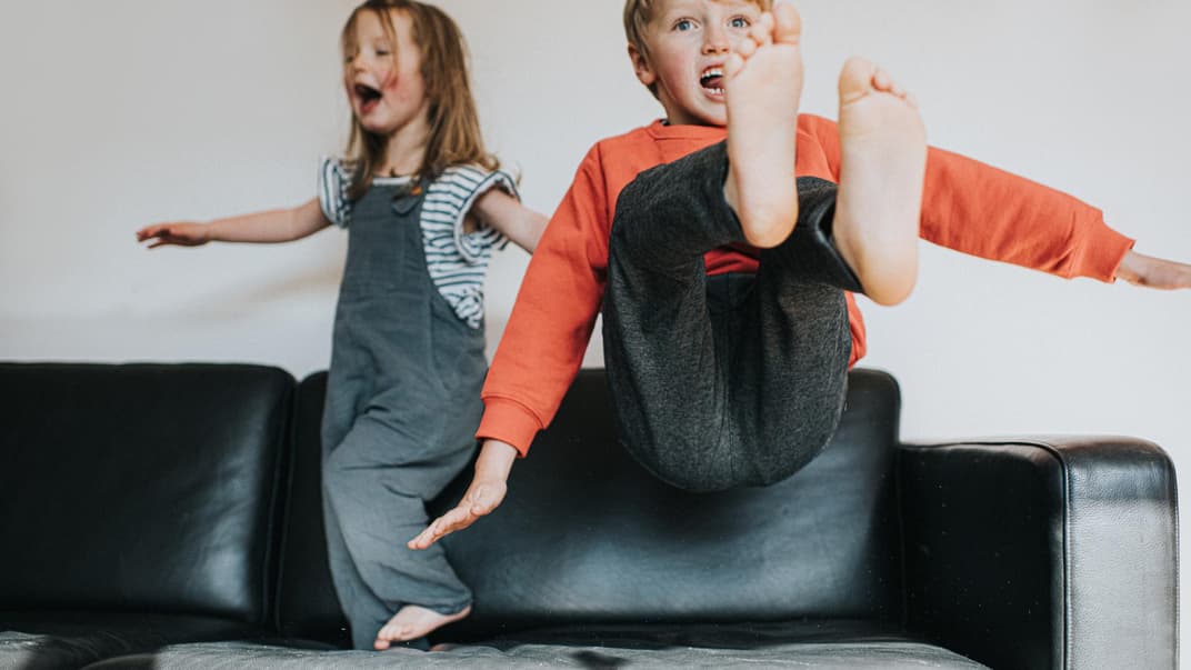 Zwei auf dem Sofa tobende Kinder