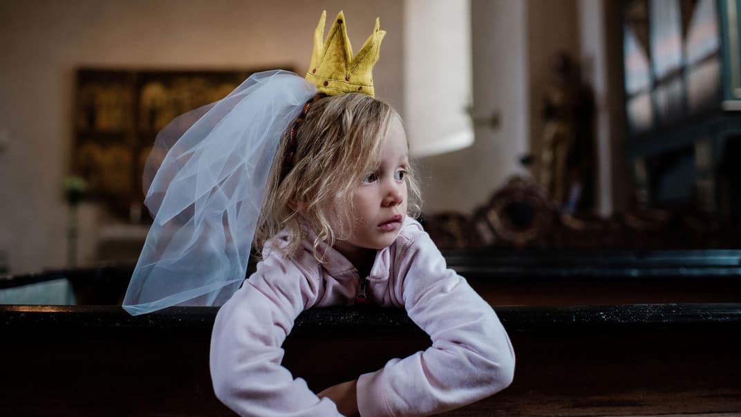 Kind, als Prinzessin verkleidet, schaut enttäuscht.