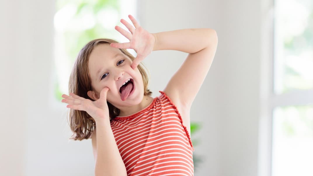 Kind schneidet eine Grimasse.