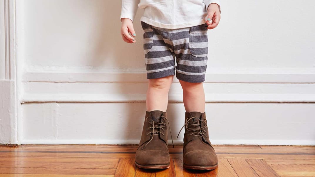 Kleinkind mit viel zu großen Schuhen.