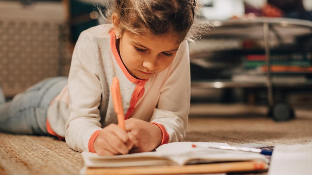 Ein junges Mädchen schreibt in ein Poesiealbum.