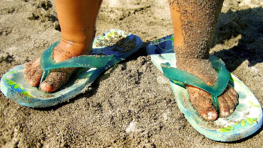 Kinderfüße voll mit klebrigem Sand