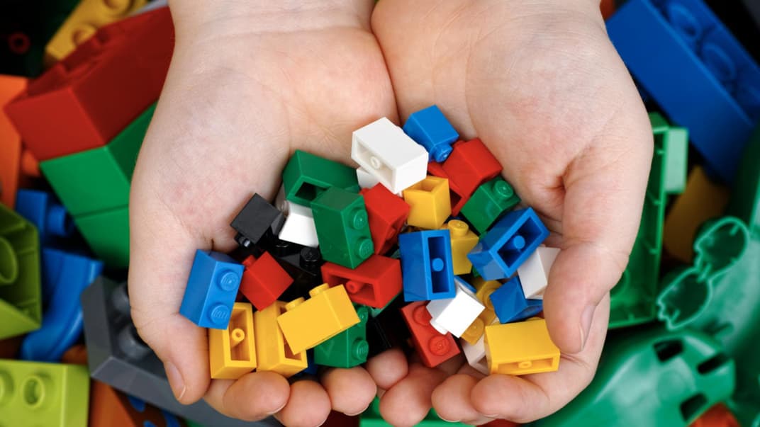 Kinderhände mit Legosteinen.