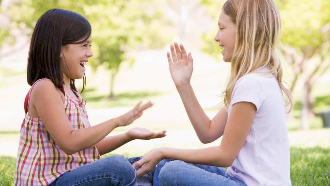 Zwei Mädchen spielen ein Klatschspiel.