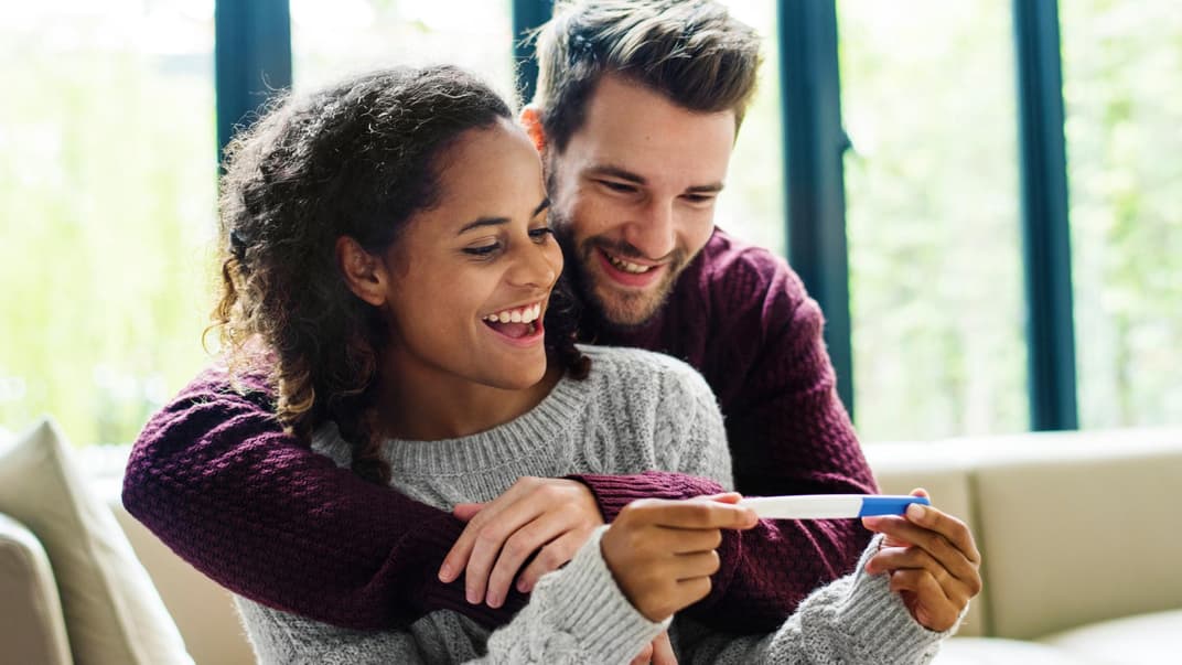 Paar freut sich über Schwangerschaftstest.