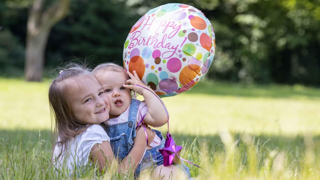 Geschwister mit Luftballon.