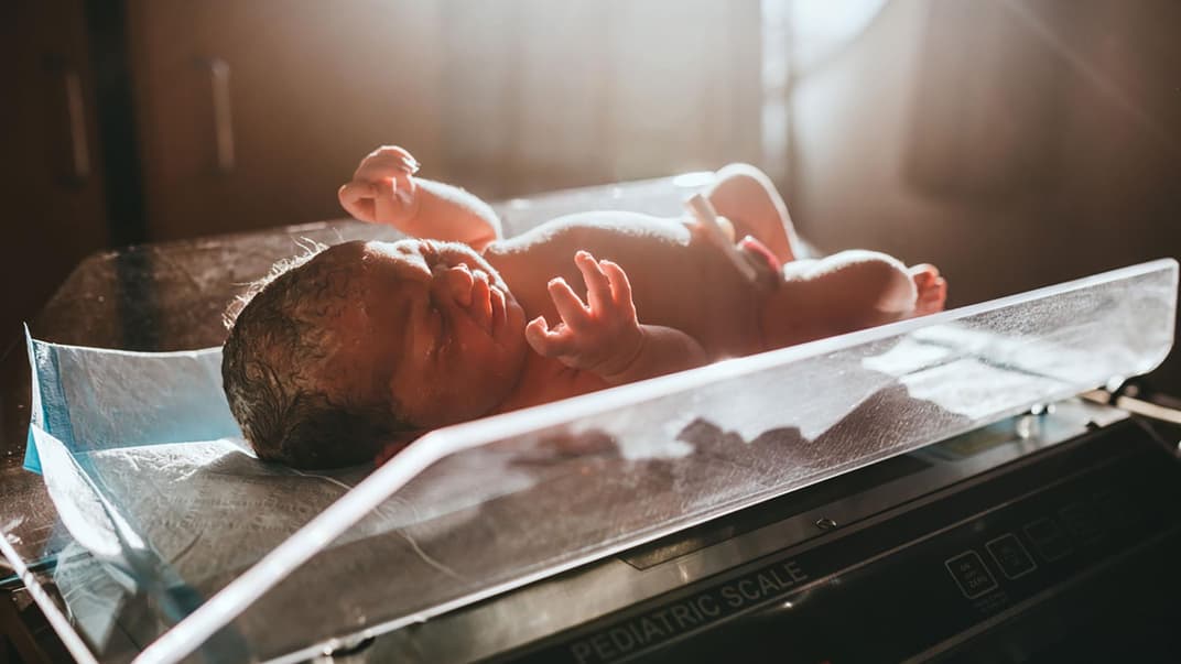 Neugeborenes auf der Waage.