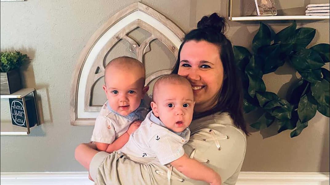 Frau mit Zwillingen, die nicht gleich alt sind.