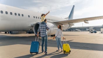Familie mit schulpflichtigem Kind am Flughafen.