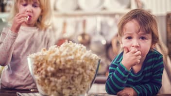 Zwei kleine Kinder essen Popcorn 