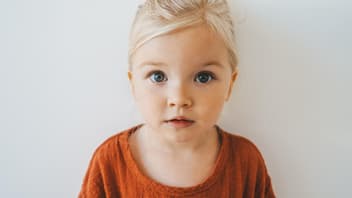 Blondes Mädchen schaut in die Kamera.