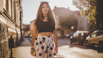 Mutter trägt bauchfrei und läuft durch die Stadt.