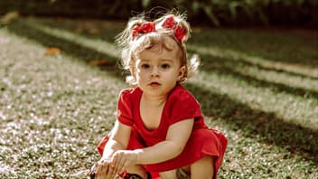 Ein kleines Mädchen hockt im Garten